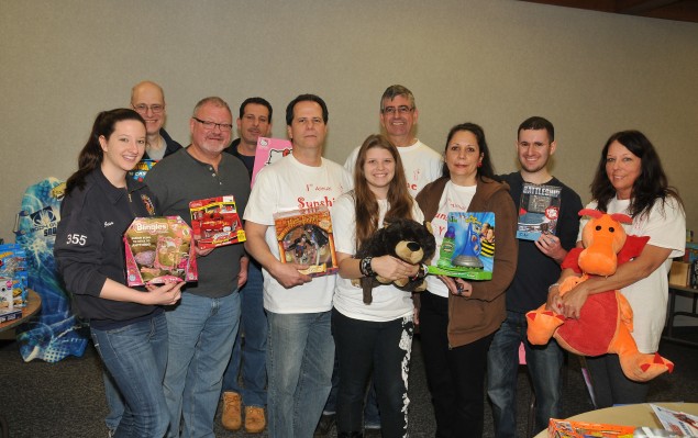 Victoria Plumitallo, center, with her parents Mike and Hope and volunteers at the Sunshine Toy Drive at the Dix Hills Fire Department. (Photo by Steve Silverman)
