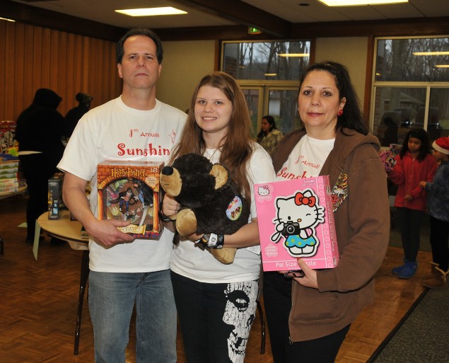 Victoria Plumitallo, center, with her dad Mike, left, and mom Hope, at right, at the Sunshine Toy Drive. (Photo by Steve Silverman)