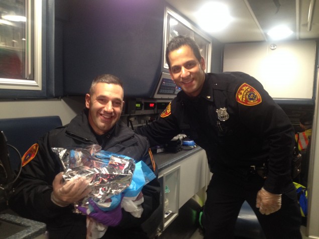 Police Officers Joseph Ferro and Gerard Maxim with the baby they helped deliver. 