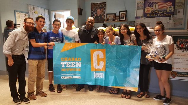 Rabbi Dovid Weinbaum with CTeen youth members and an officer at the 2nd Precinct in Huntington, NY